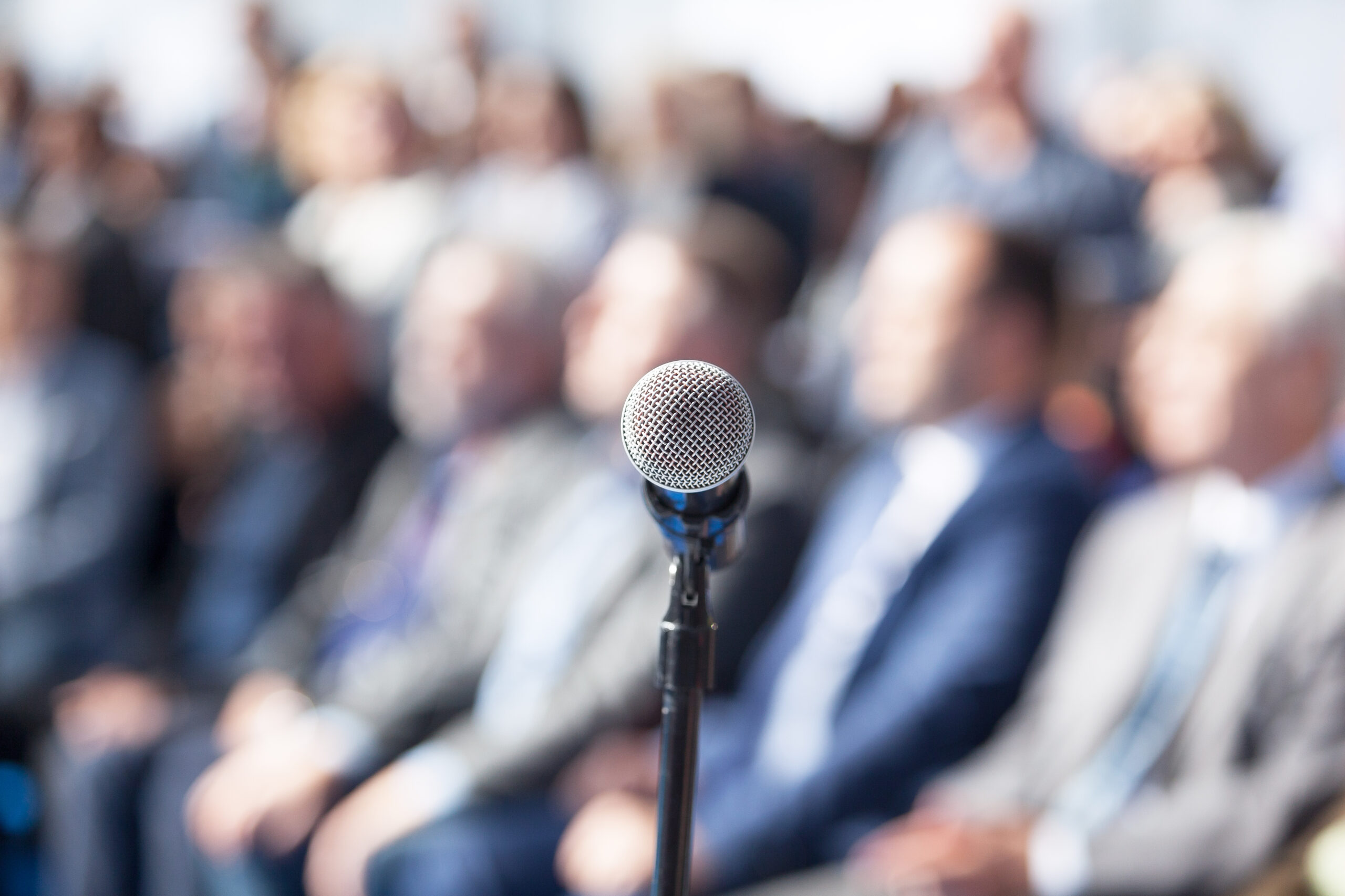Microphone in focus against blurred audience